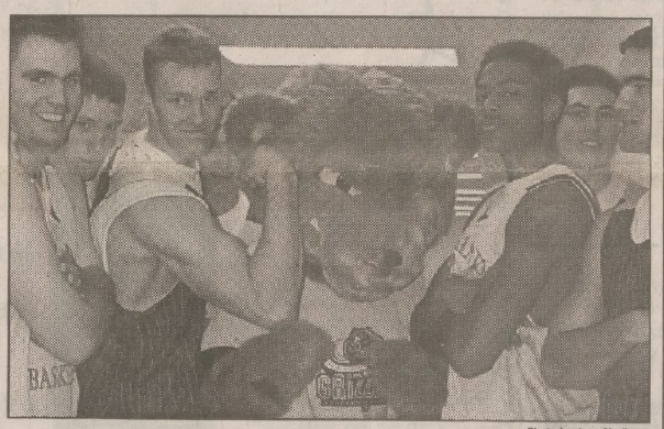 Grizzly mascot standing with basketball players
