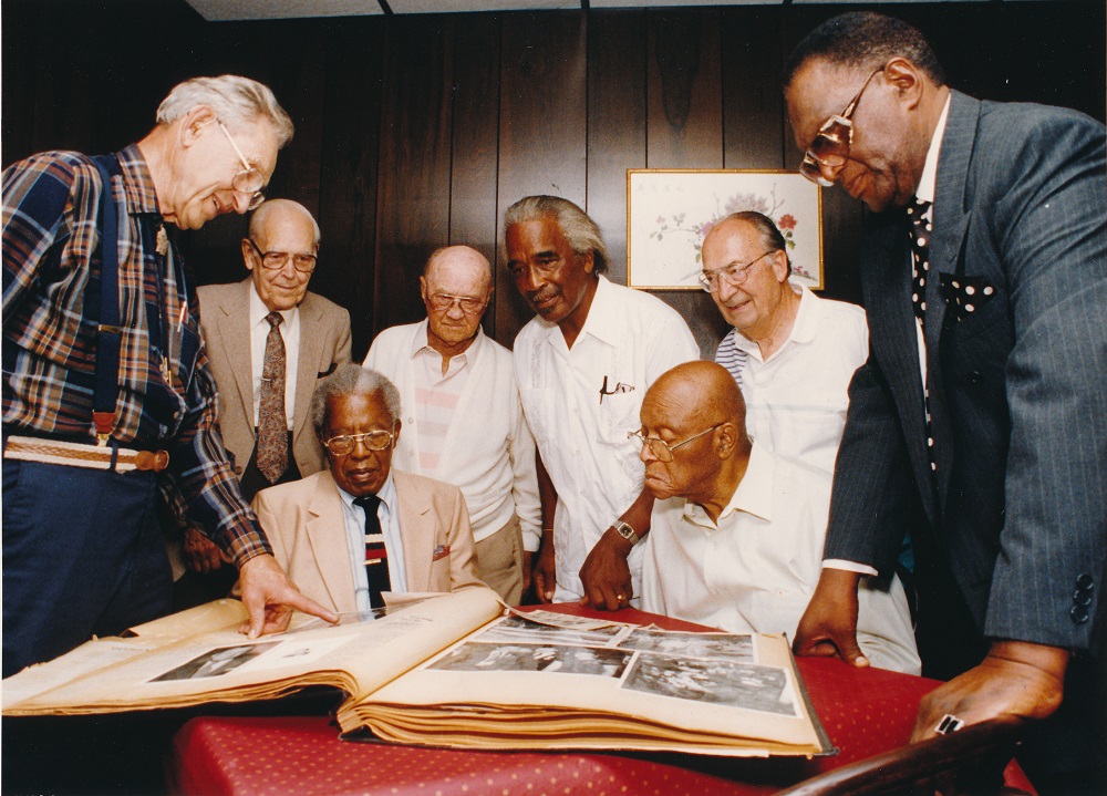 Oakland Press photo of Thomas C Holland and several others viewing a photobook